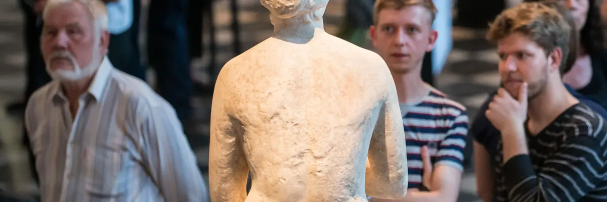 Besucher, die sich eine Skulptur anschauen