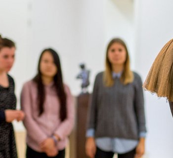 Besucher betrachten Skulptur in einer Führung