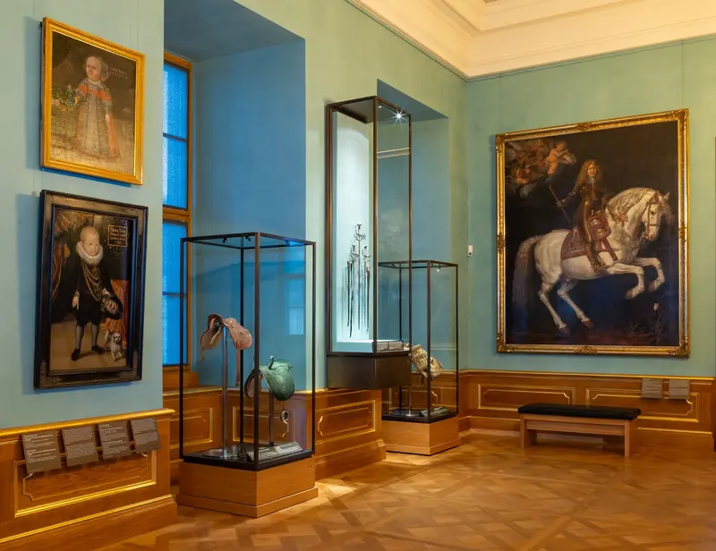 festlicher Saal mit Vitrinen und Gemälde an der Wand